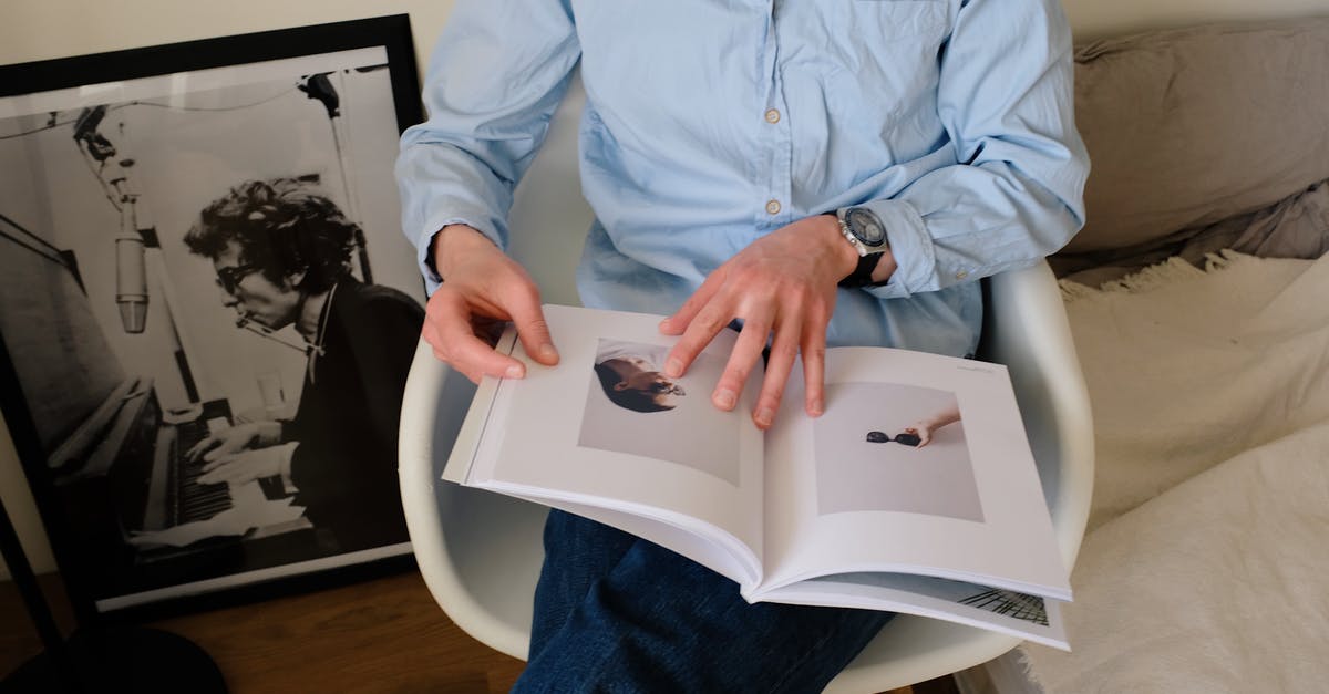 Staple through picture page of passport [closed] - Unrecognizable man sitting with book on chair