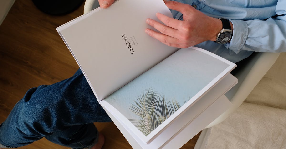 Staple through picture page of passport [closed] - Faceless man with wristwatch looking through magazine