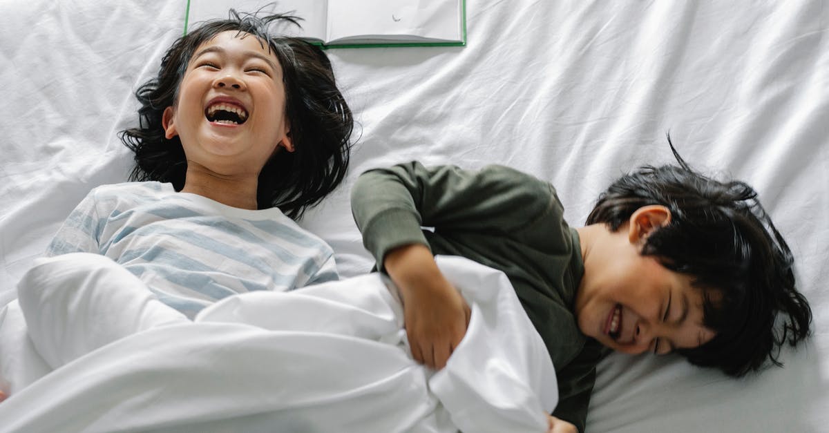 Stay Awake or Sleep to Minimize Jetlag? - Smiling Asian kids in bed