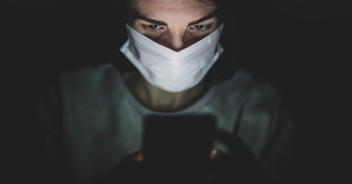 Staying in Johannesburg for a few months: how safe am I as a white person? - Man Wearing Face Mask Using His Phone In The Dark