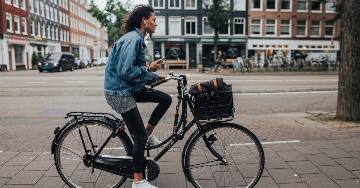 Staying near Rotterdam en-route to Cologne and visiting Amsterdam - Man in Blue Denim Jacket and Black Denim Jeans Riding Black Bicycle