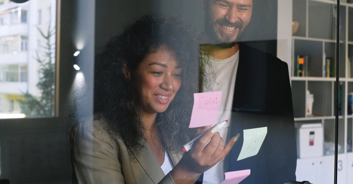 Sticker on passport - Diverse happy business partners checking stickers on glass door and smiling together in office