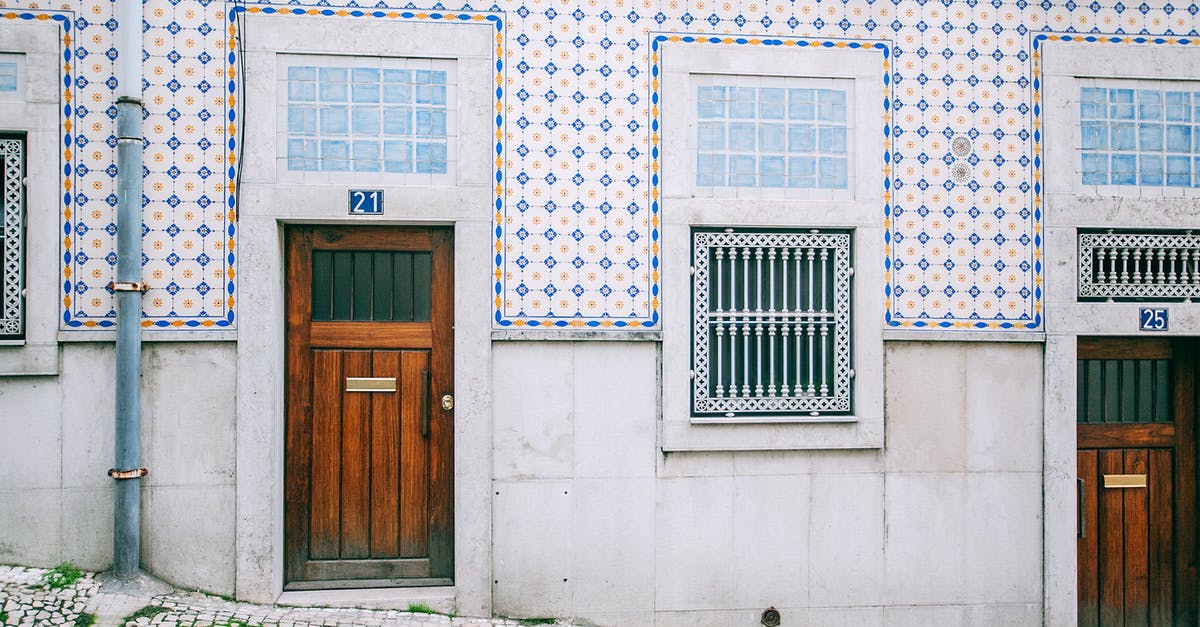 Sticking to the declared itinerary for exiting Schengen area - Facade of modern residential building with wooden doors and ornamental tiled walls in daylight