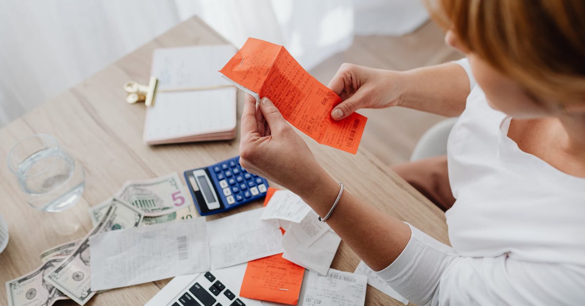 Strange currency on websites Argentina - Woman Sorting Receipts at the Desk at Home 