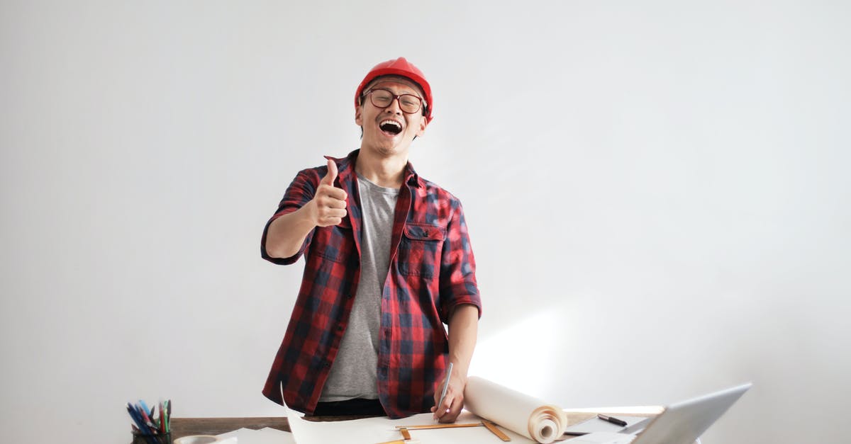 Strategy to improve seats on a flight? - Laughing male constructor showing thumb up at working desk