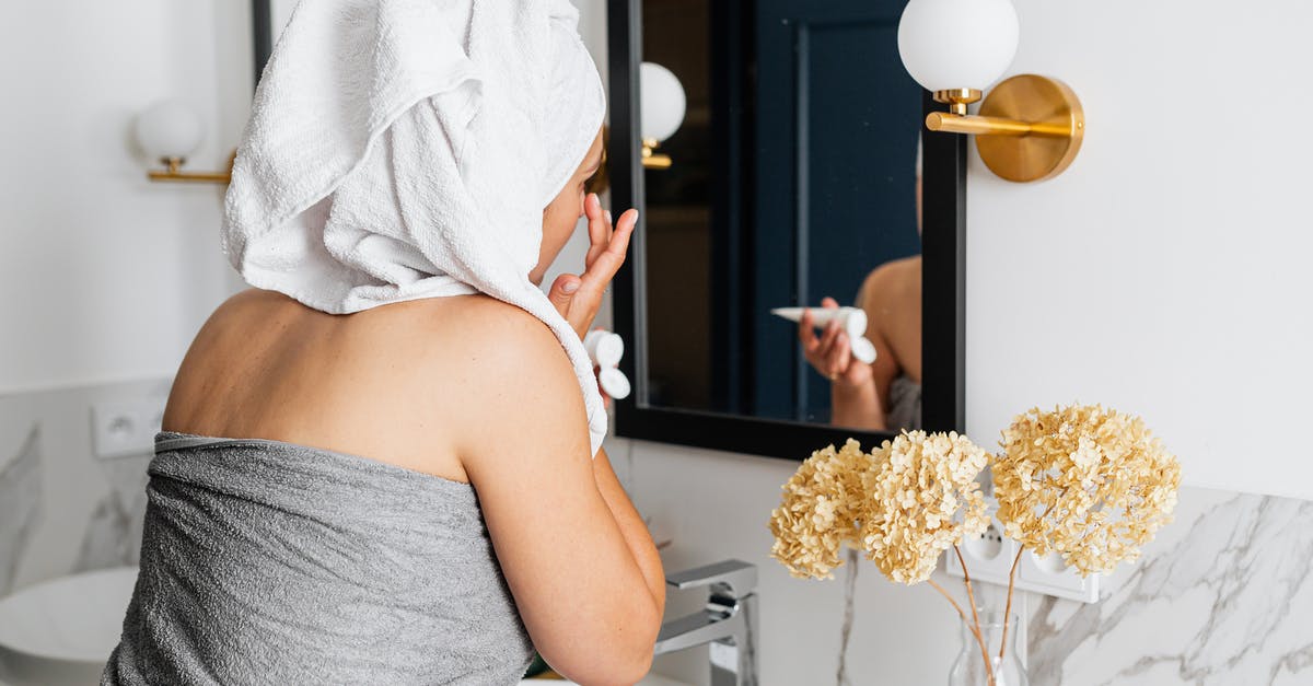 Strategy while applying for a UK visa after a refusal - Woman Applying Face Cream in Front of a Mirror