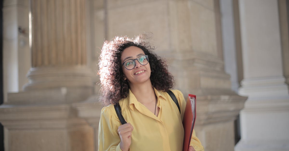 Student Visa come as a tourist before it expires - Cheerful young clever student with papers and backpack on campus