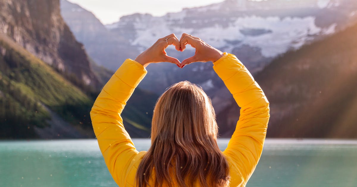 Submitting Canada visa application for Holiday in Canada - Back View Of Woman in Yellow Long Sleeve Shirt With Heart Hand Gesture