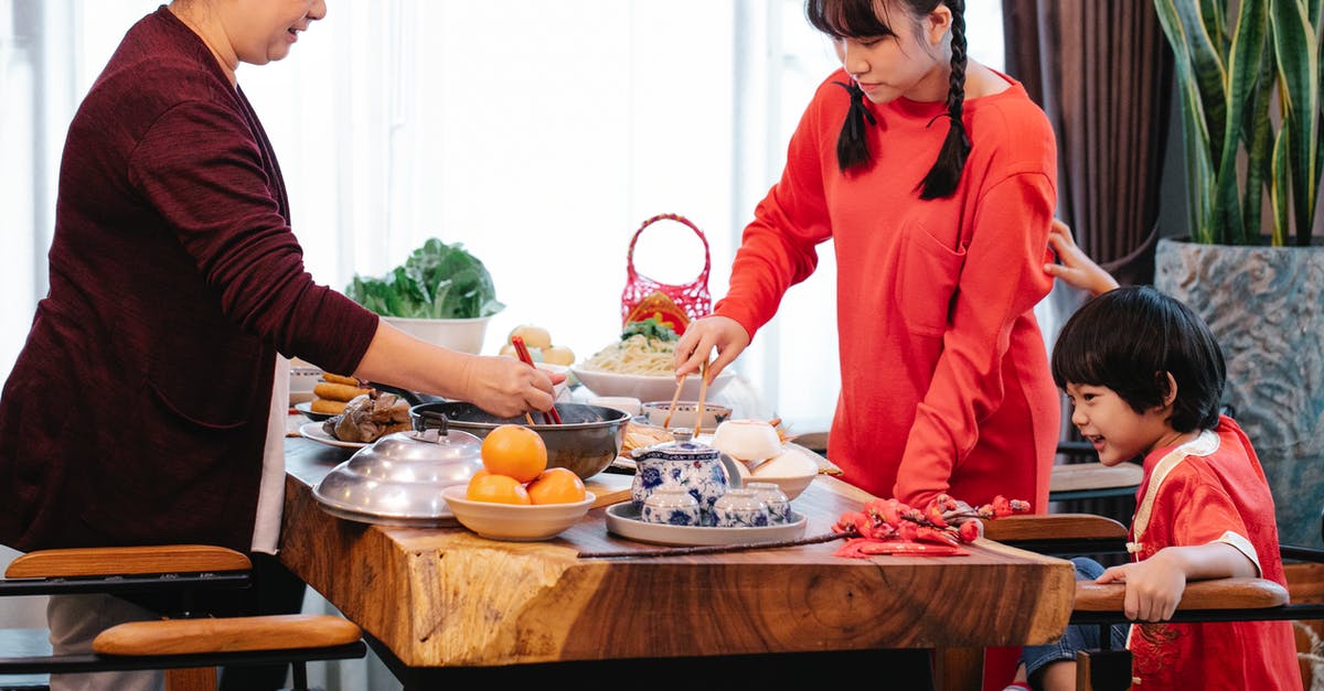 Suggestions for 15 year old ( child / teen ) travelling alone - Crop smiling Asian grandmother with boy and teen serving food