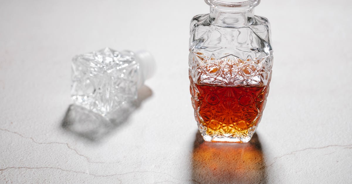 Suitcases: hard or soft?  Canvas, polycarbonate or something else? - From above of open crystal glass jug with alcoholic beverage placed on white table with cracks