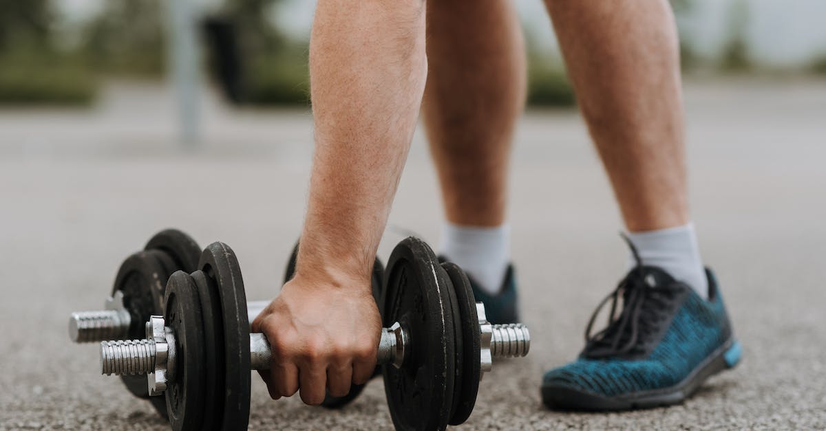 Suitcases: hard or soft?  Canvas, polycarbonate or something else? - Man touching massive iron dumbbell