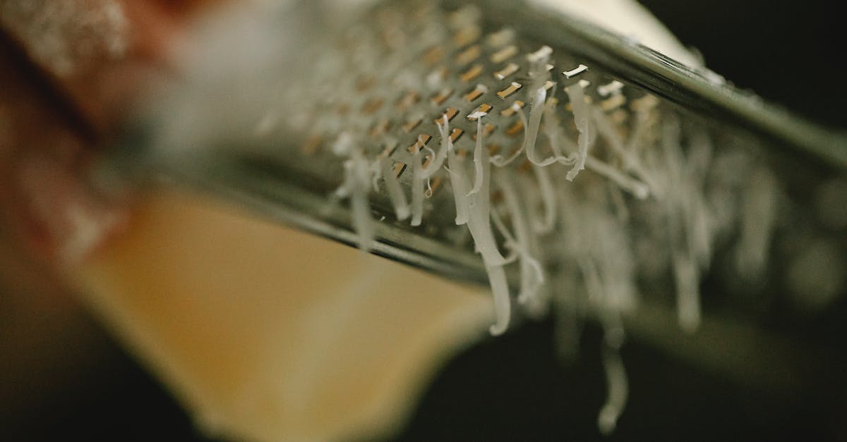 Suitcases: hard or soft?  Canvas, polycarbonate or something else? - Crop unrecognizable chef grating delicious cheese on narrow stainless grater in dark kitchen