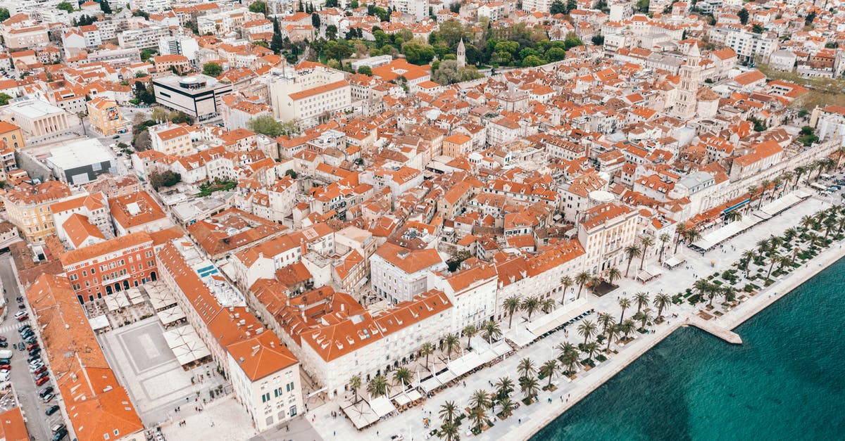 Summer Sea Travel from Dubrovnik to Split - Coastal town embankment with red roofed buildings