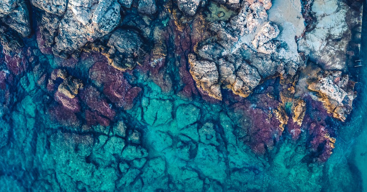 Summer skiing in Europe [duplicate] - Aerial Photography of Rocks Beside Body of Water