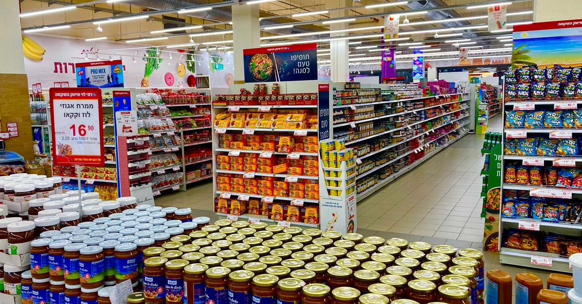 Supermarket evaluation and rating in France - Blue and White Labeled Bottles on White Shelf