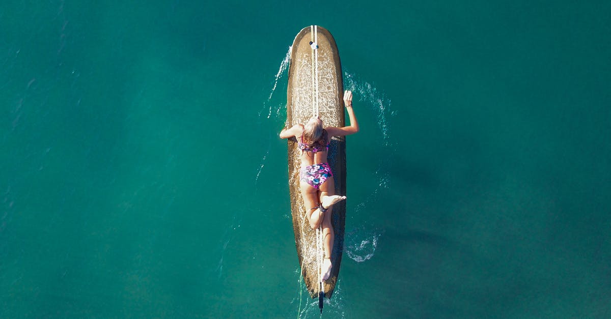 Swimwear customs on Côte d'Azur? - Female surfer floating on surfboard in sea