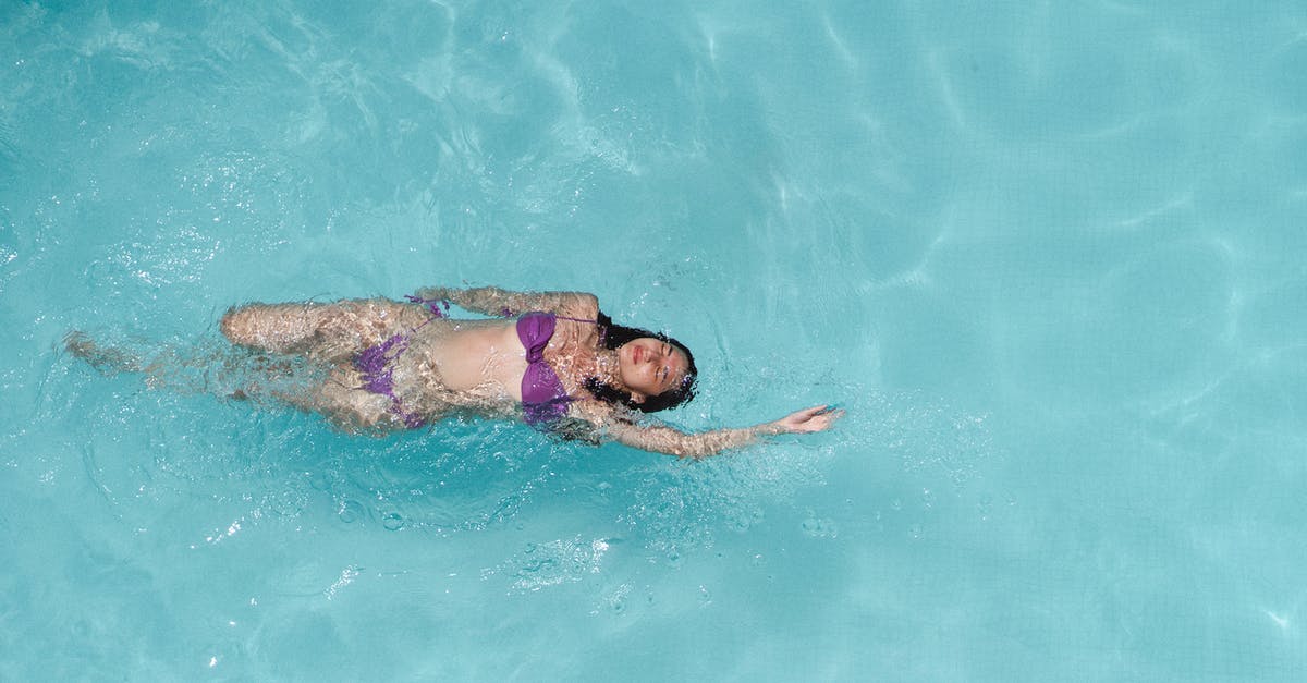 Swimwear customs on Côte d'Azur? - From above of young slim woman in violet bikini floating on back in crystal clear seawater on sunny summer day