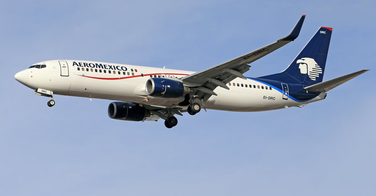 Switching airline carriers at layovers - A White and Blue Airplane Flying in the Sky