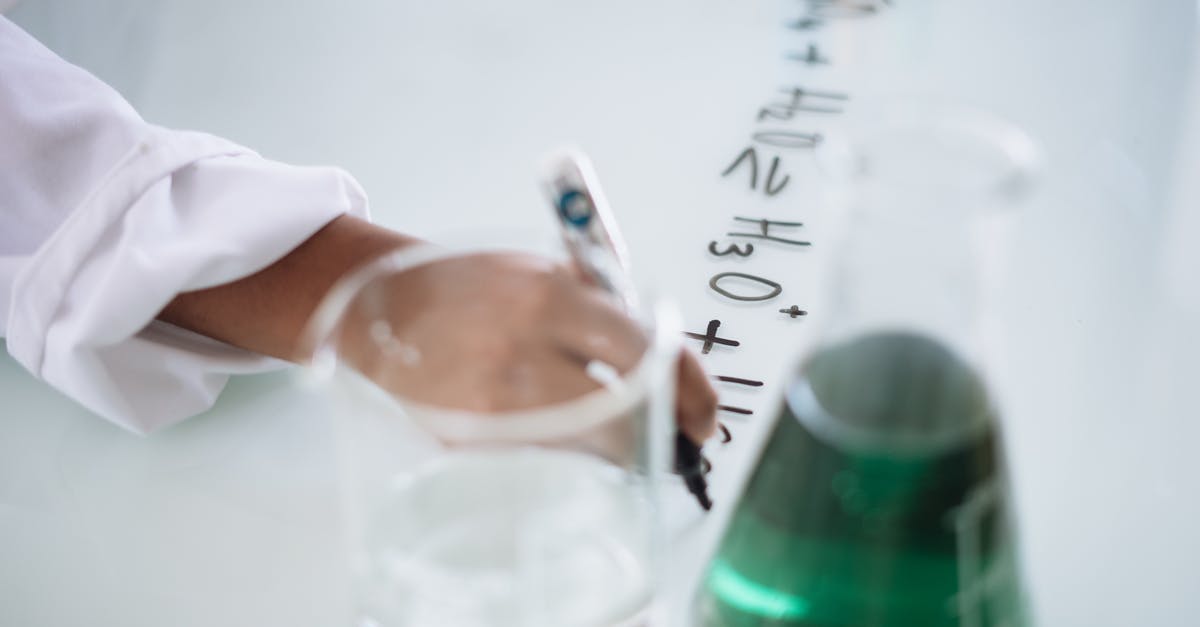 Take test or obtain result 72 hours before arrival? (Flying to Lithuania) - Body part of unrecognizable scientist in white uniform writing down formula after providing chemical research with fluid in flask during science lesson in university Take test or obtain result 72 hours before arrival? (Flying to Lithuania) - Body part of unrecognizable scientist in white uniform writing down formula after providing chemical research with fluid in flask during science lesson in university