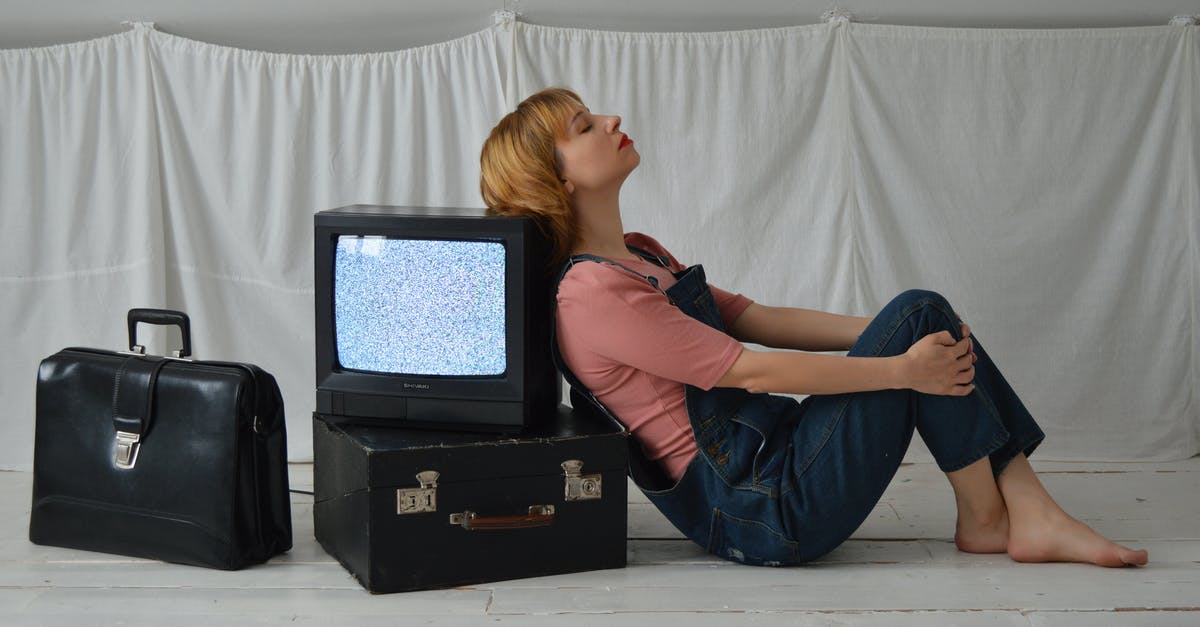 Taking 40" TV to northern Cyprus as baggage? - Thoughtful woman laying back on retro TV set on floor