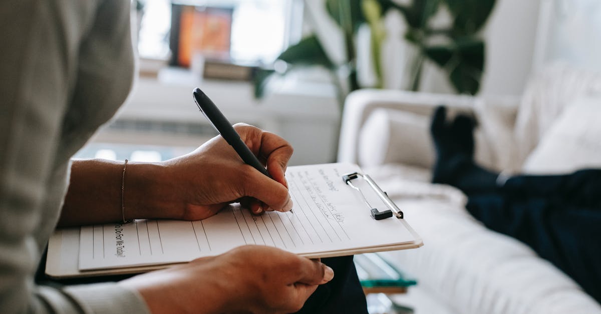 Taking a drone inside the Louvre? - Unrecognizable ethnic female therapist taking notes on clipboard while filling out form during psychological appointment with anonymous client lying on blurred background