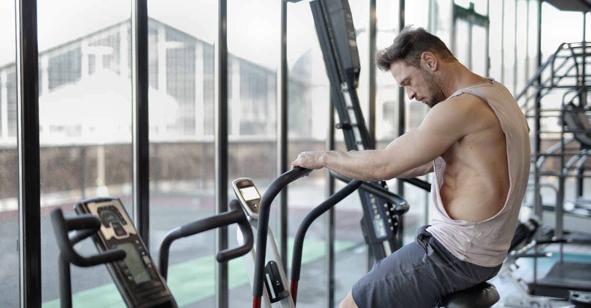 Taking bike as luggage from Bratislava to Vienna - Strong sportsman using exercise bike in gym