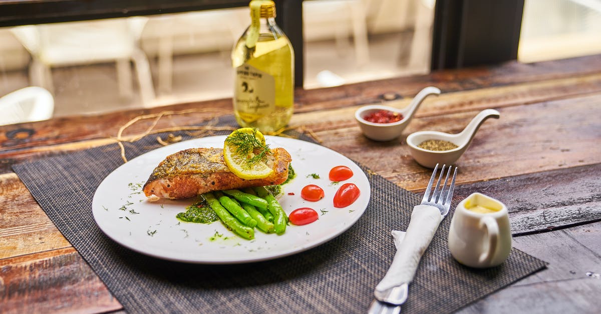 Taking olive oil from Turkey to Germany in check-in luggage? - High angle of served plate with fried fish and vegetables placed near saucers with spices and olive oil