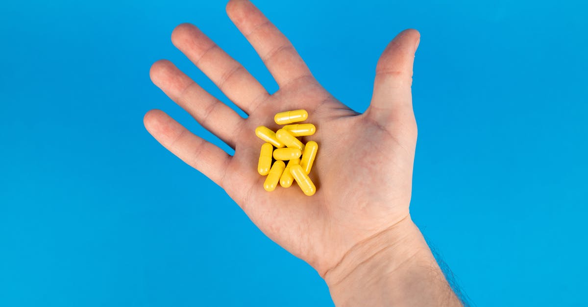 Taking personal prescription drugs to London? - Person Holding Yellow Capsules