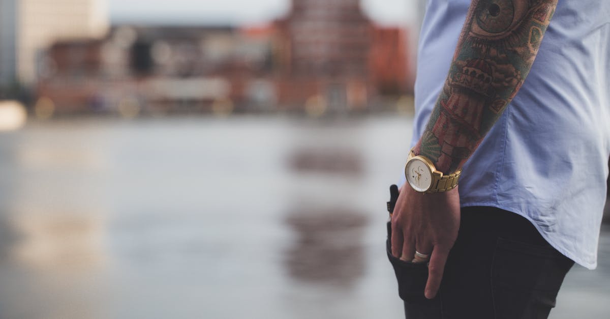 Tattoos while Traveling Overseas - Selective Focus Photography of Man Wearing Blue Shirt