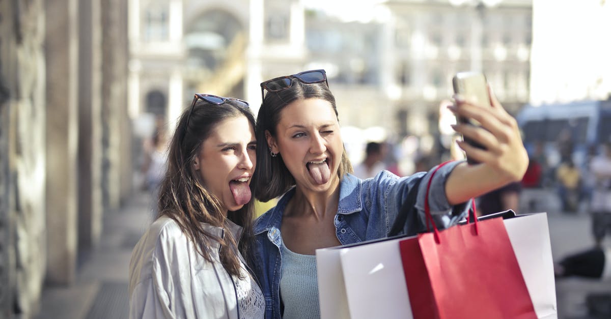 Tax-free shopping in Faroe Islands - Cheerful young women with shopping bags taking selfie on street