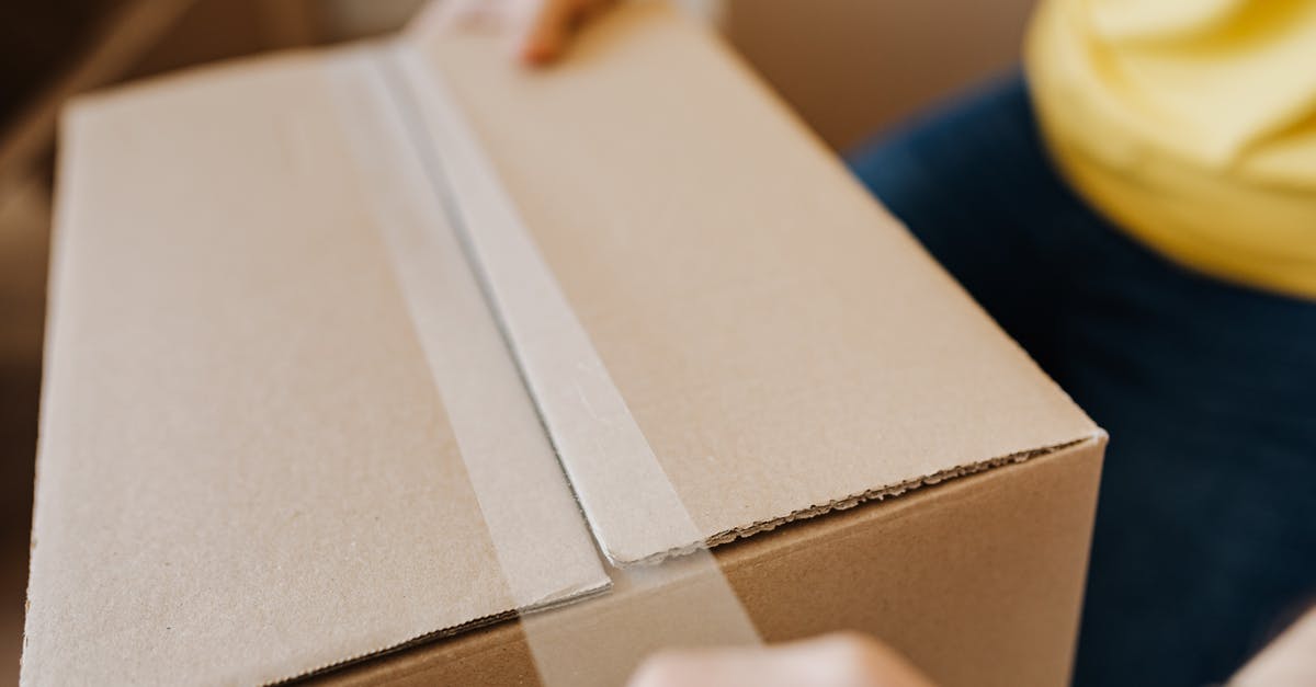 Temporary lock for rented accommodation [closed] - Crop man sealing cardboard box with tape