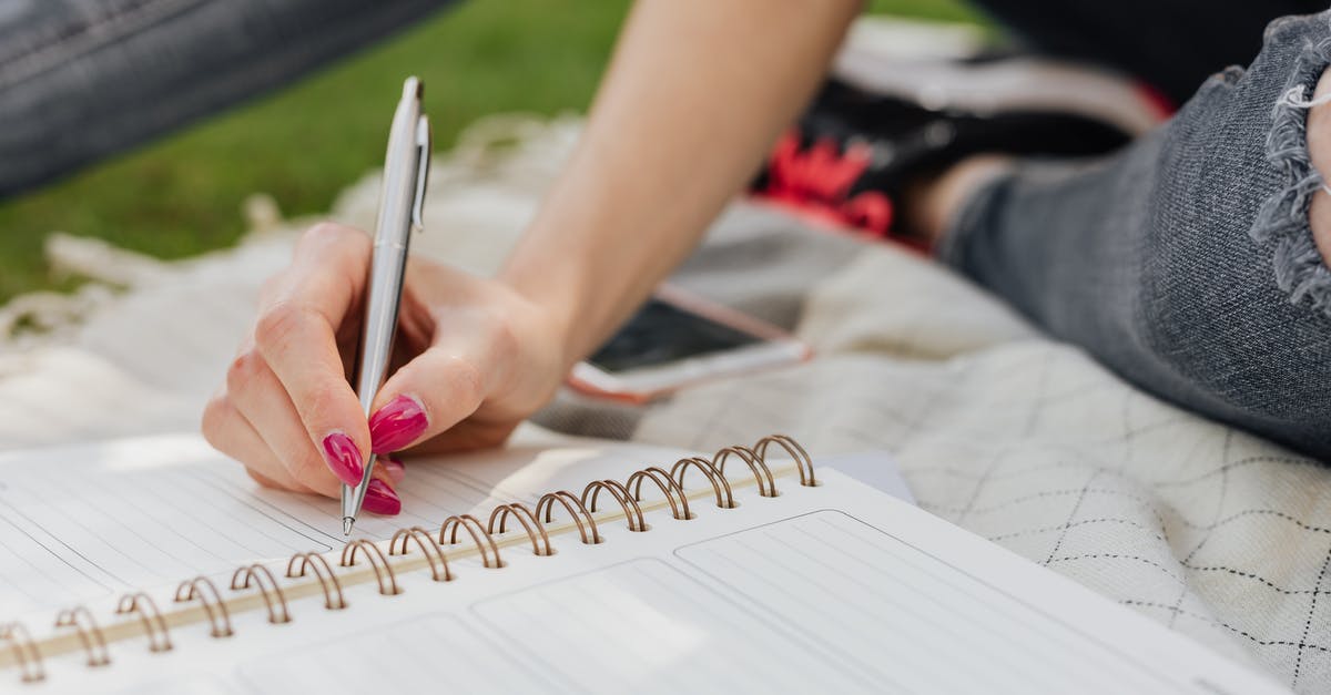 TGV timetables / schedules? - Crop anonymous lady in casual wear writing down plans for next day in organizer while sitting on blanket in quiet summer park