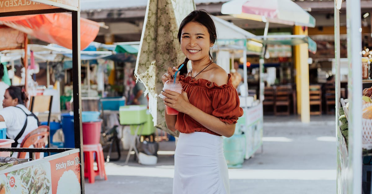 Thai Tourist Visa and Exemption - Woman in Brown Long Sleeve Shirt and White Skirt Holding Umbrella