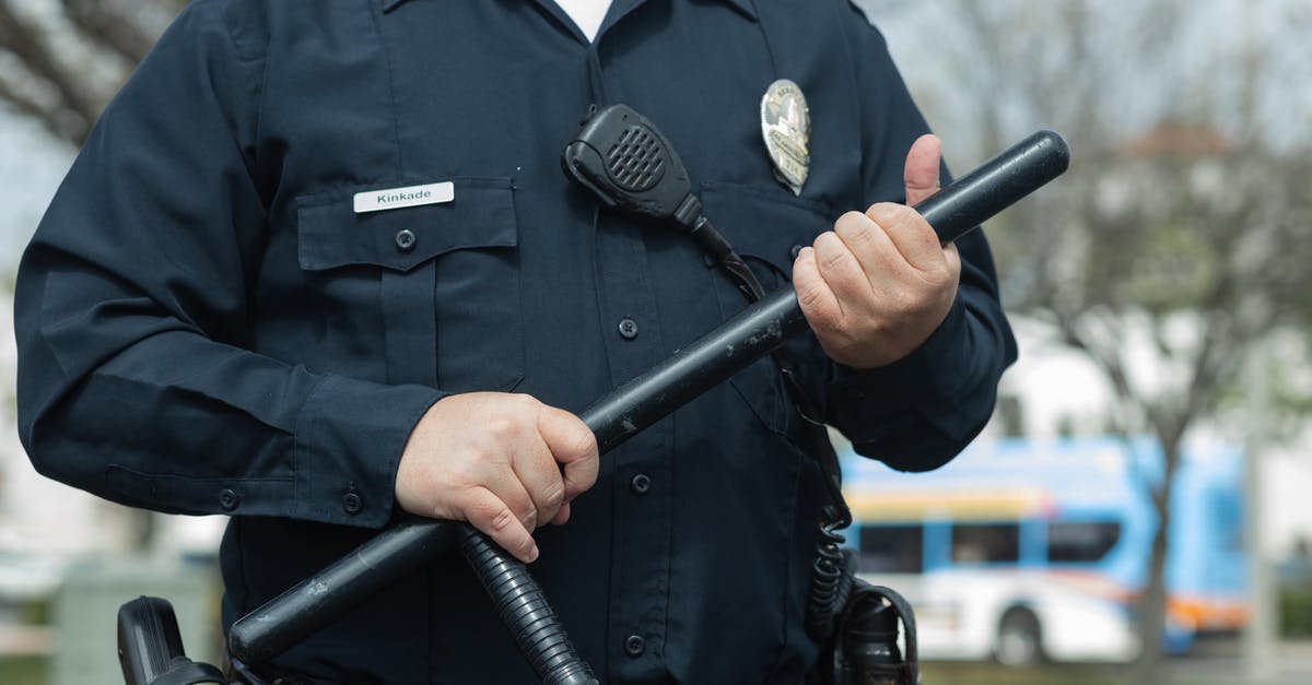 The officer wrote a "code" in my passport - Man in Black Police Uniform Holding Black Metal Rod