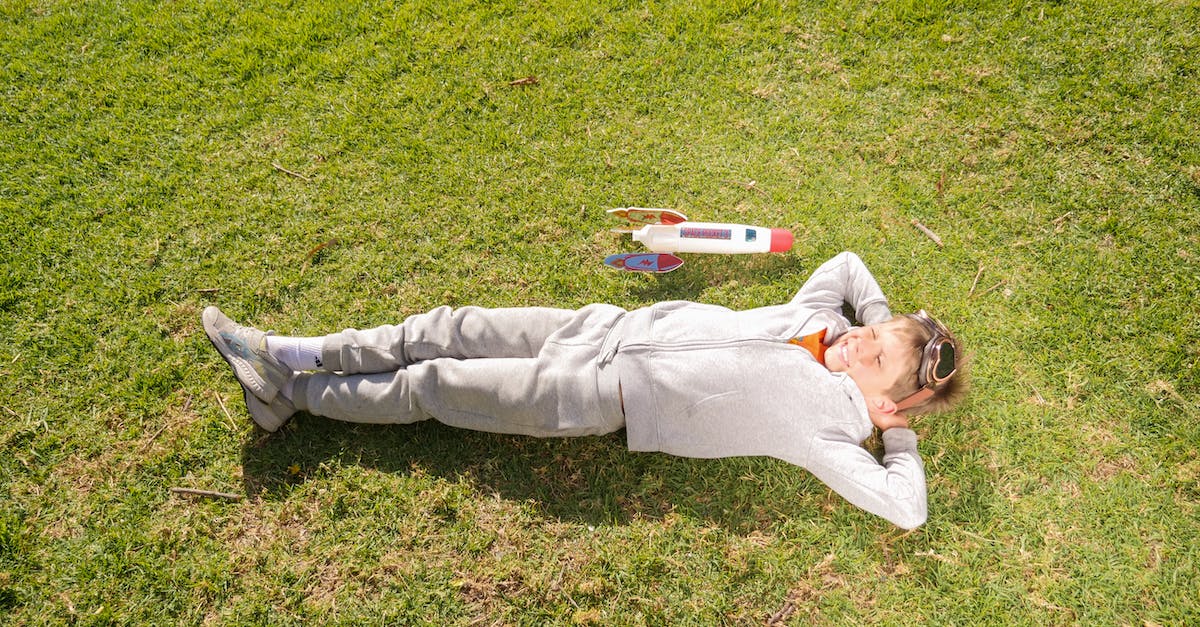 Things to do with young children in Paris in August - Man in Gray Pants Lying on Green Grass Field