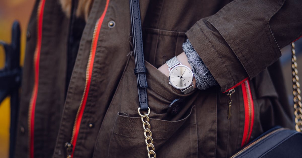 Time to Recheck Bag? - Woman Brown Coat Wearing Silver Analog Watch While Hand in Her Pocket