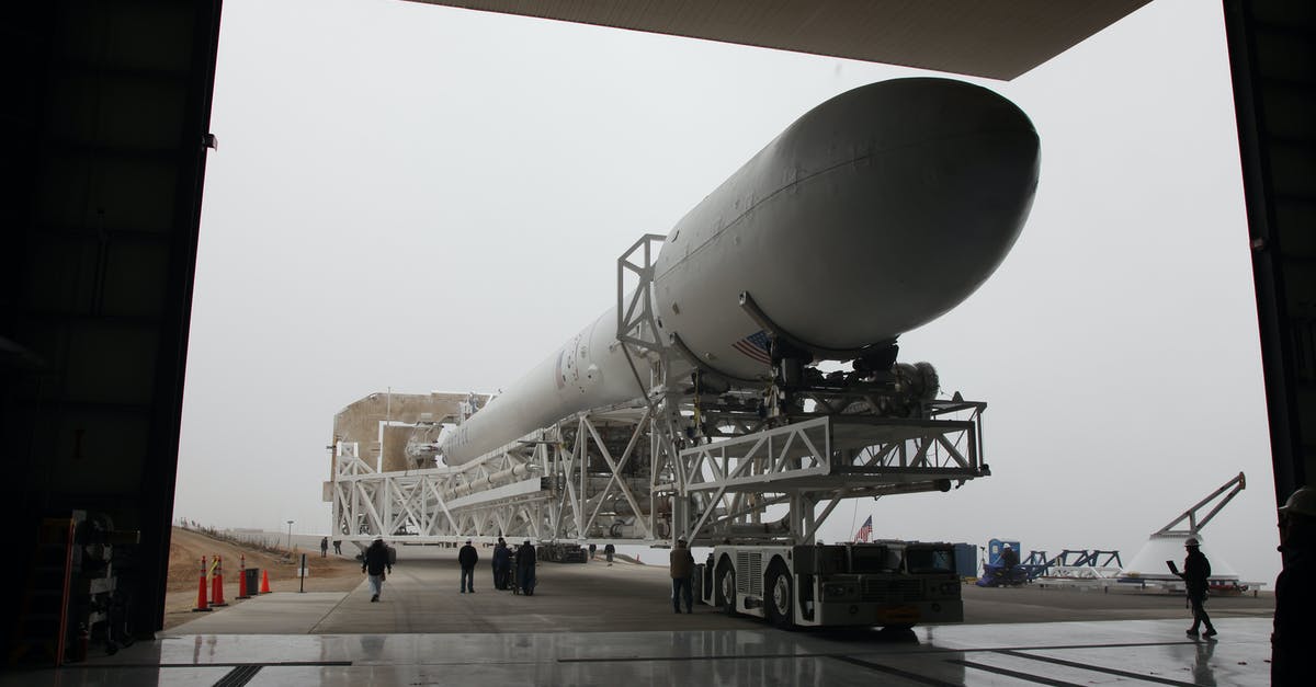 Tipping for pre-paid shuttle service in the US? - New installed rocket booster placed on transporter platform and moving into vehicle assembly building in space center on cloudy day
