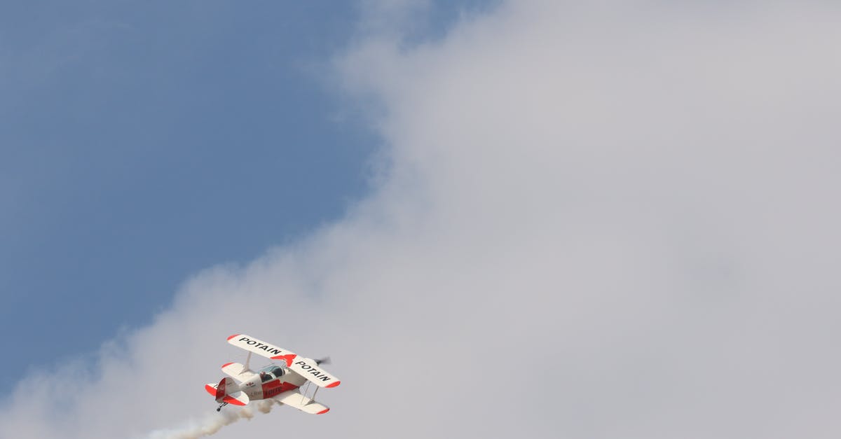 Tips and tricks surviving a long-haul flight departing at midnight - White and Red Biplane Flying during White Cloudy Day