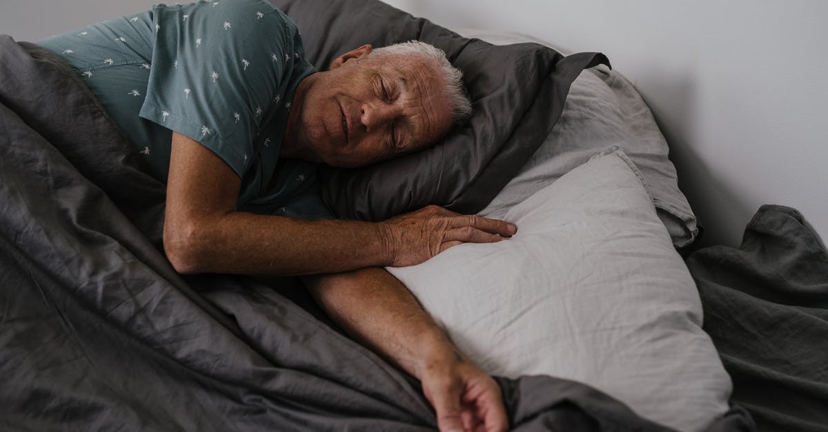 Tips for sleeping in a Couchette sleeping carriage? - Man in Grey T-shirt Lying on Bed