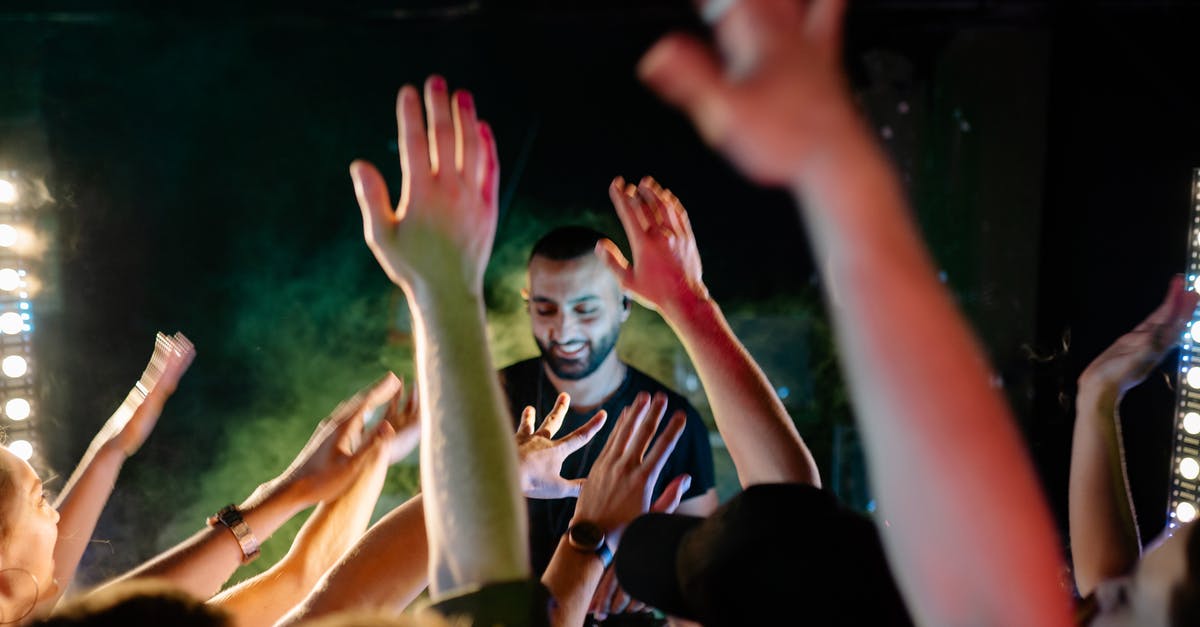 To have mStand in hand-luggage in Europe? - People Raising Their Hands during Nighttime