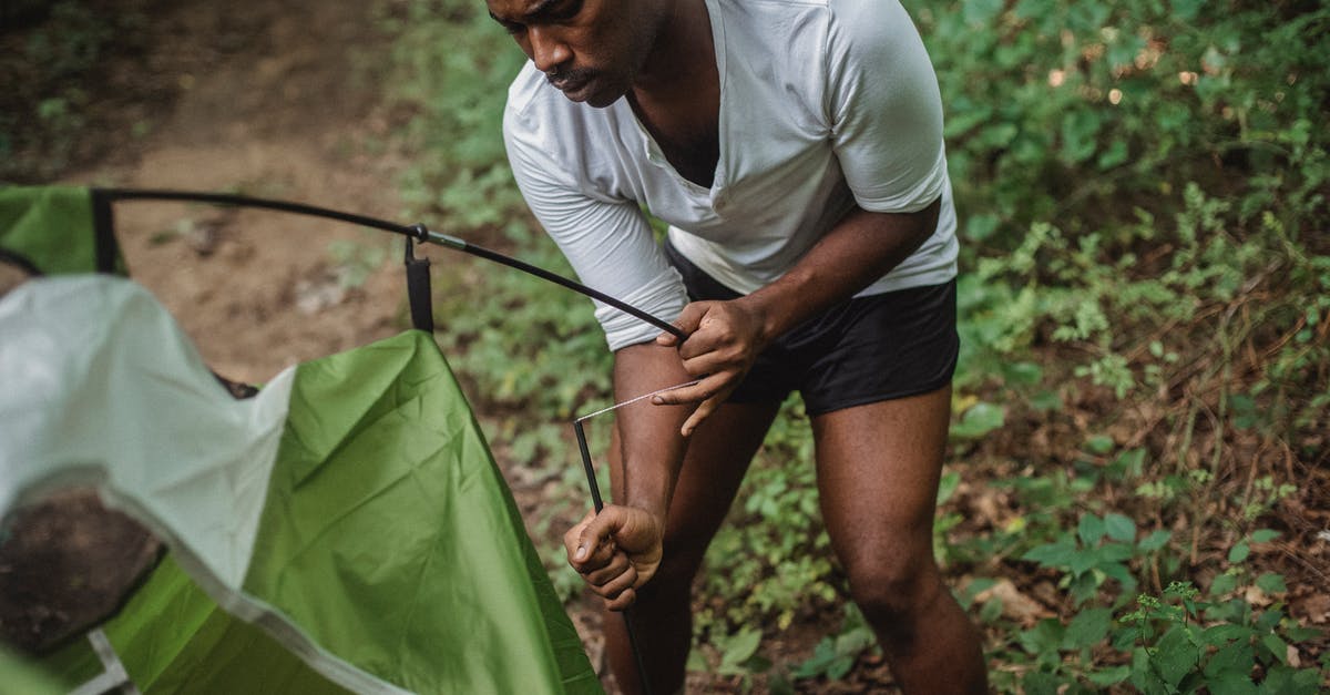 Tourist on ICT Short term visa? - Serious black traveler trying to set up tent in forest