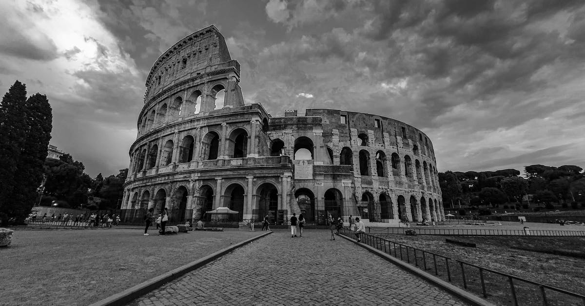 Tourist visa for Spain with adverse UK Immigration history - Black and white of historic Colosseum with tourists walking on paved square in Madrid