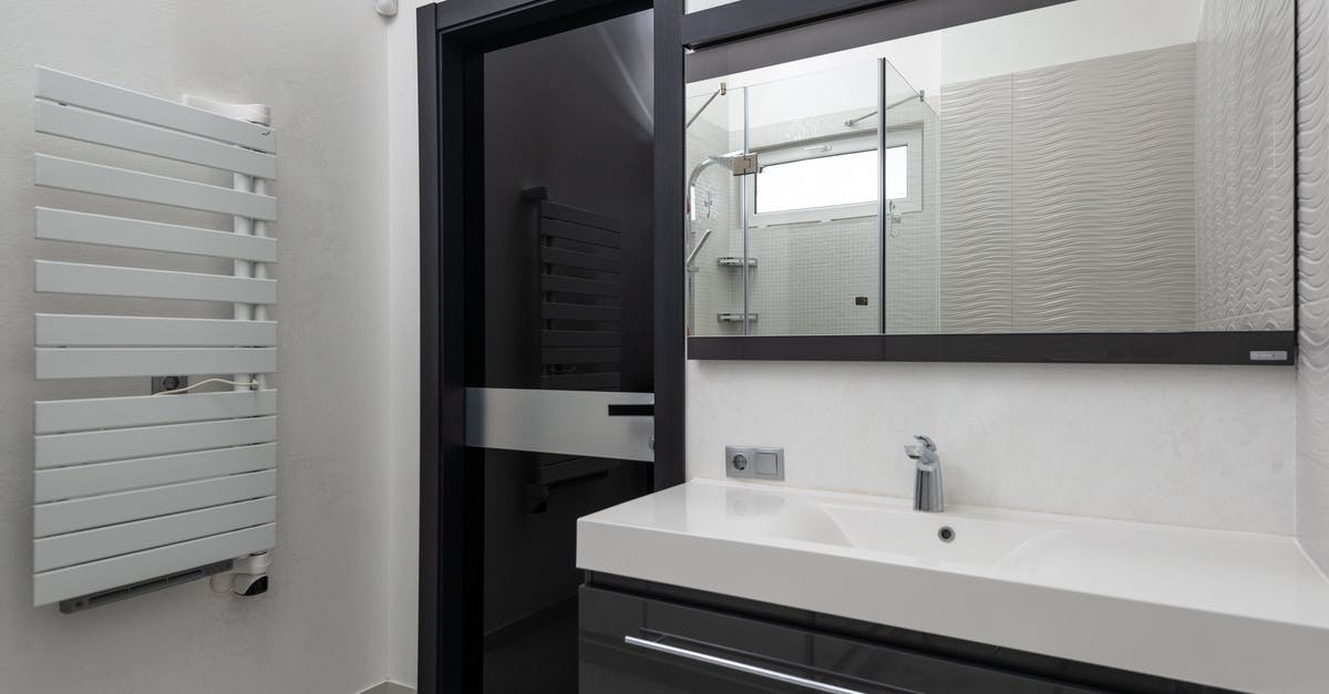 Towel heater switch - Creative design of bathroom with door between heated towel rail and washstand under rectangular mirror in light house