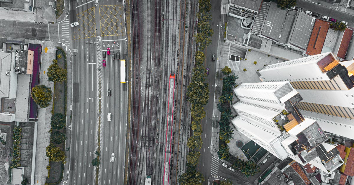 Train Route from CDG to Calais - Top view of asphalt roadways and railroads with driving vehicles near high house facades in town