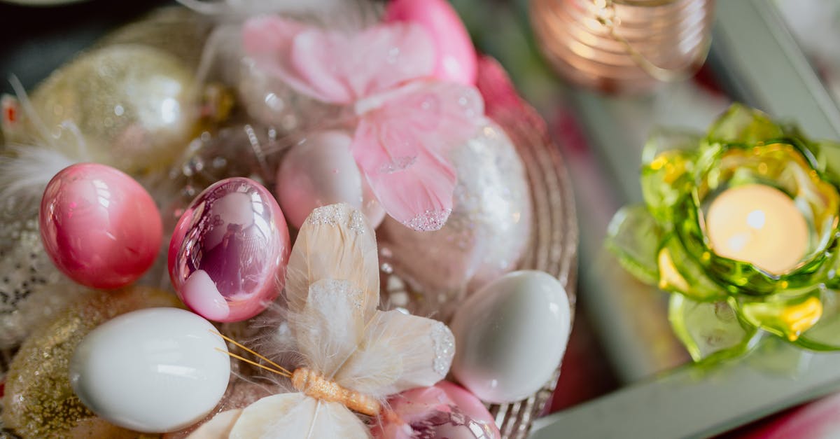 Train timetable over Easter holidays in Sydney - From above of shiny Easter eggs in bowl with decorative artificial butterflies placed on glass table with small candle