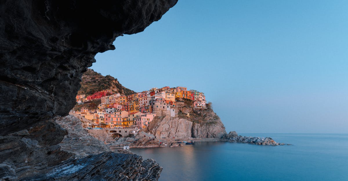 Trains in the Cinque Terre - View on magnificent coastal town with colorful buildings from sea cave