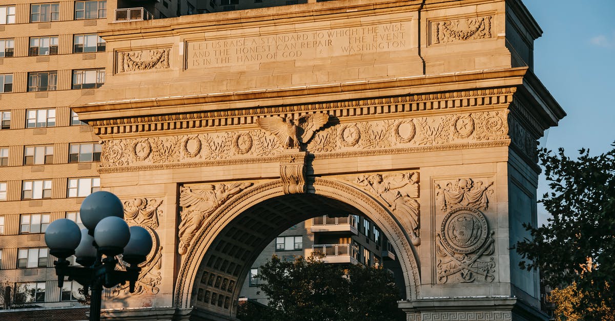 Transfer from Washington National (DCA) to Dulles(IAD) [duplicate] - From below of aged triumphal arch placed in Washington Square Park in New York City against residential building illuminated by sunlight