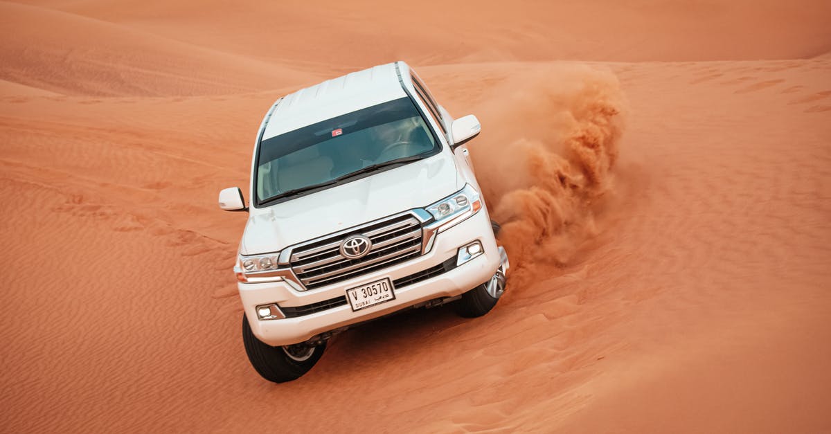 Transit visa in Dubai (landing in XNB, leaving via DXB) [duplicate] - White Vehicle Driving on the Desert Sand