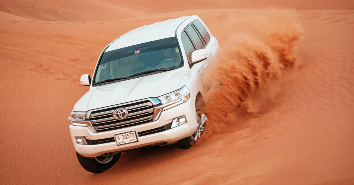 Transit visa in Dubai (landing in XNB, leaving via DXB) [duplicate] - Man Driving a Land Cruiser on the Desert