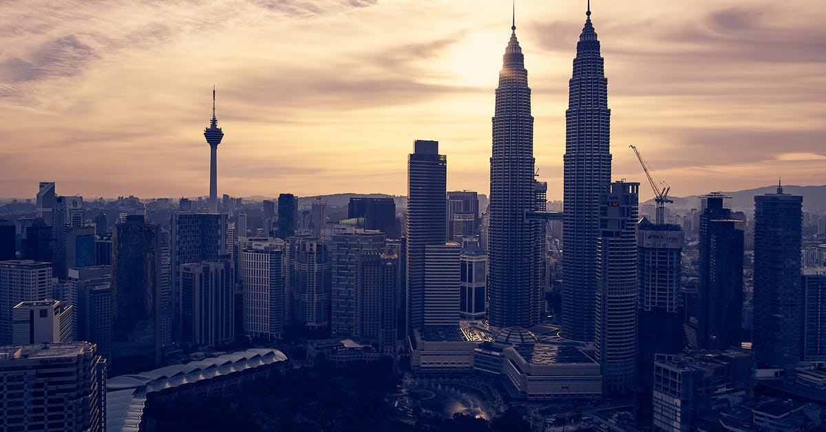 Transiting at Kuala Lumpur - View of Cityscape Against Sky during Sunset